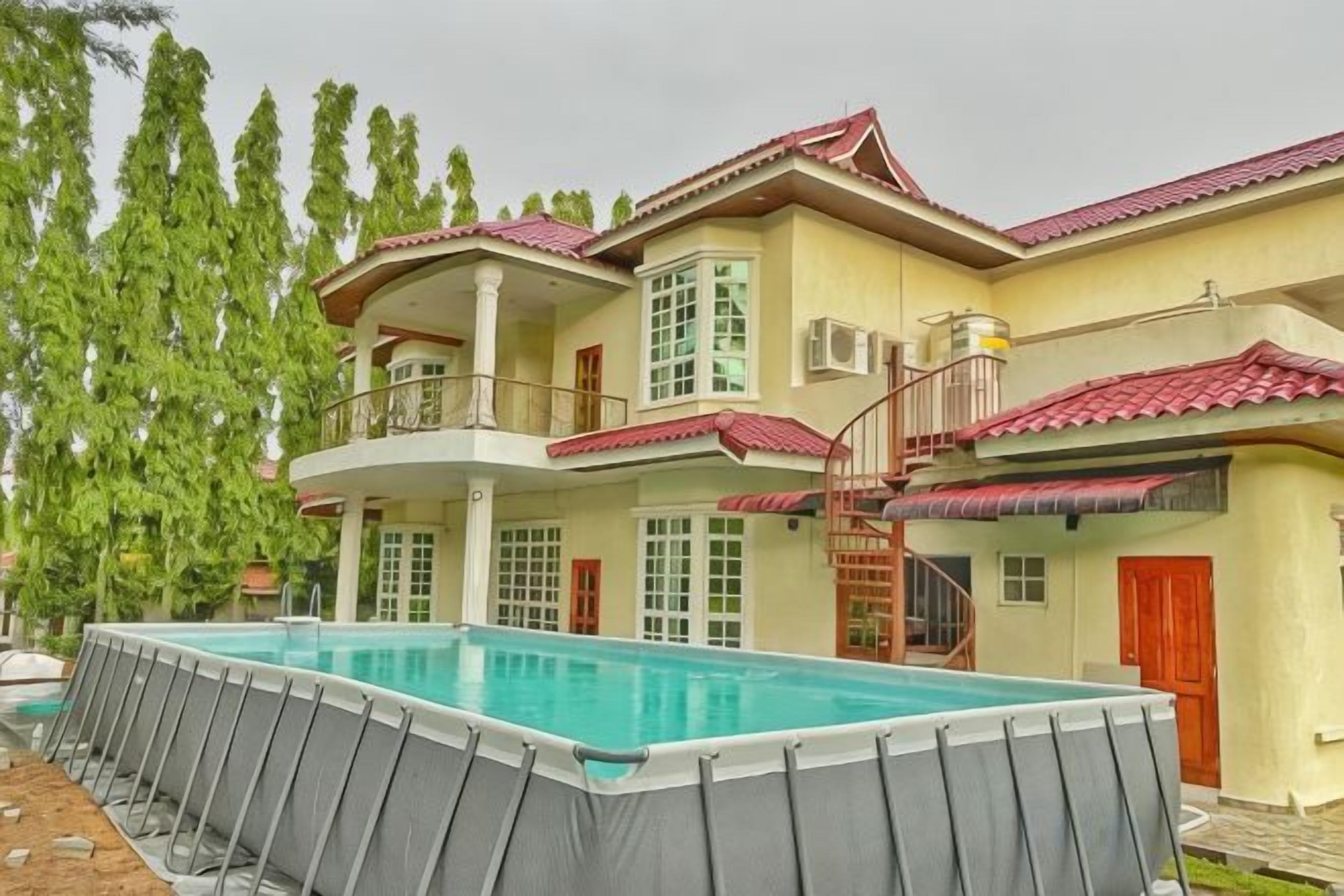 Una casa a due piani con piscina, un balcone e una scala che conduce al piano superiore.