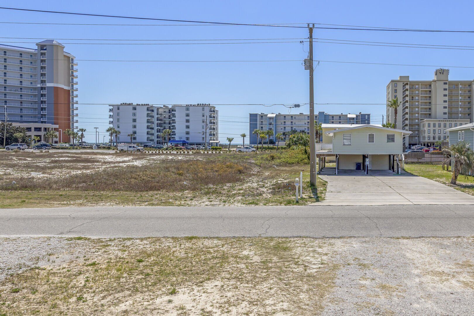 A coastal area with a small building, possibly a hotel, near a road.