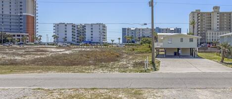 A coastal area with a small building, possibly a hotel, near a road.