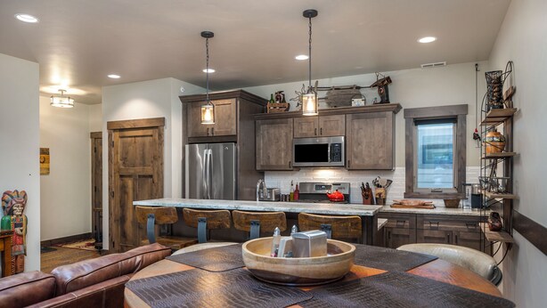 A modern kitchen with wooden cabinets, stainless steel appliances, and pendant lighting. - Downtown Whitefish condo centrally located with great views and AC (Whitefish)