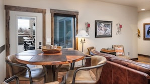 A dining area with a round table, leather chairs, and a wooden bench. - Downtown Whitefish condo centrally located with great views and AC (Whitefish)