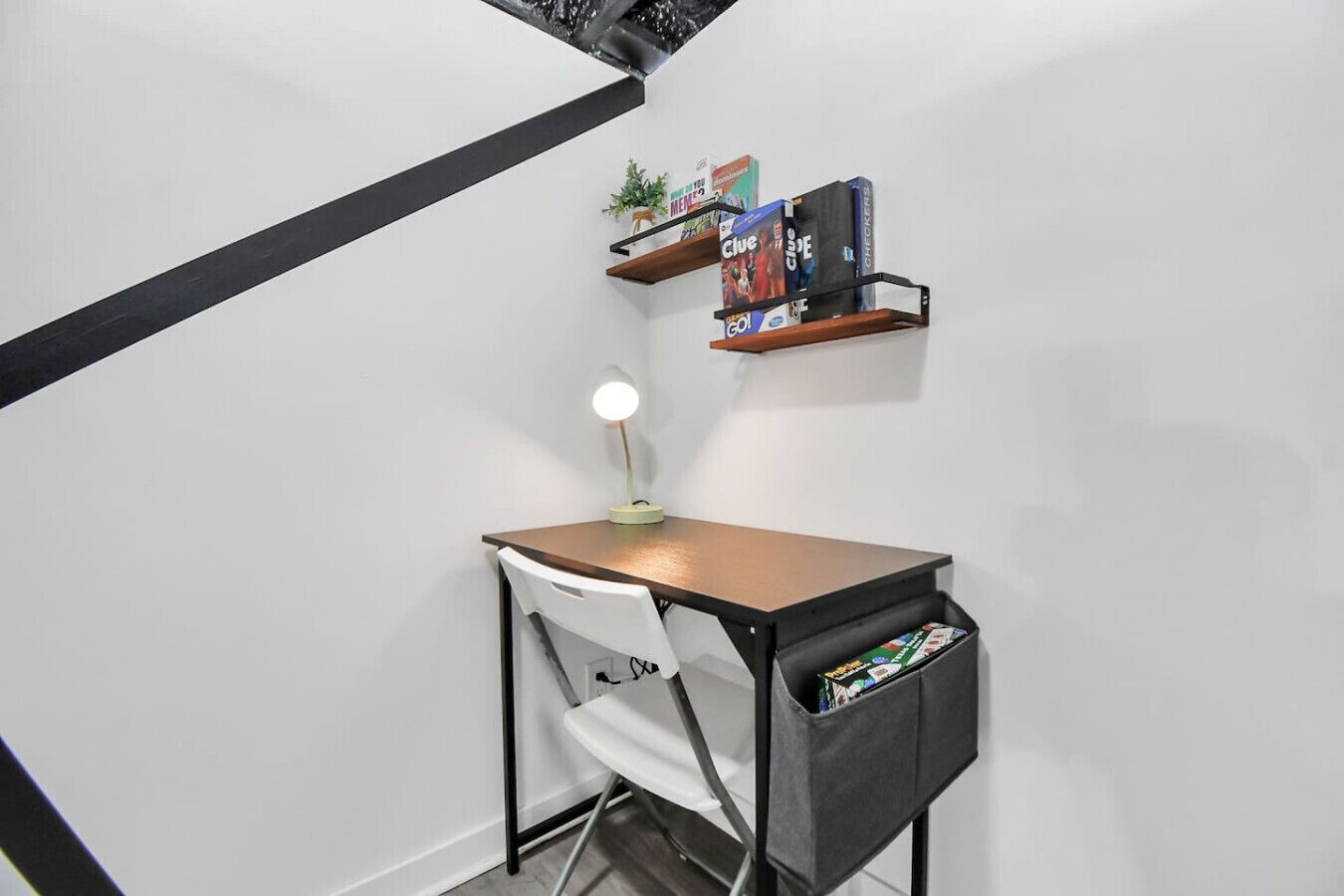 A small study area with a desk, chair, and shelves with books.