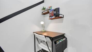A small study area with a desk, chair, and shelves with books.