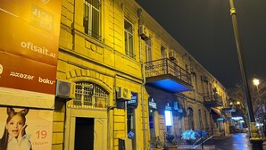 A historic building with a balcony and a sign for 'ACIBADER'. - World Hostels (Baku)