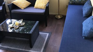 Et solbelyst rum med sofa, stol og sofabord.