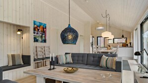 Un salon moderne avec un canapé gris, une table basse en bois et un tableau accroché au mur.