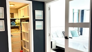 A bedroom with a bed, a chair, a wardrobe, and a closet.