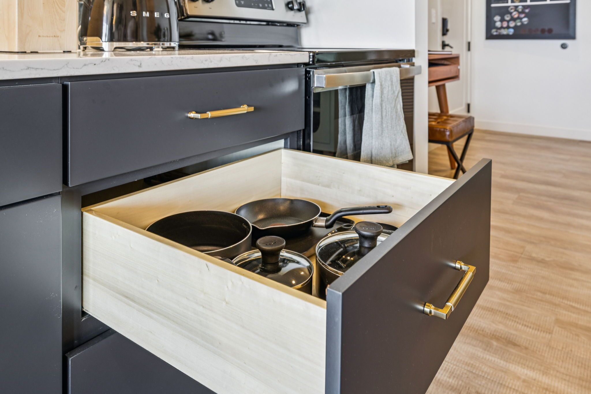Un cajón de la cocina con varias ollas y sartenes.