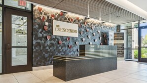 A reception desk with a sign reading "The Crescendo" in a modern lobby with patterned walls and a tiled floor. - H&O on Music Row (Nashville)