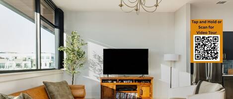 Condo de lujo, balcón, vista a la ciudad | Área de sala de estar | Smart TV de 65 pulgadas con canales digitales y consola de videojuegos