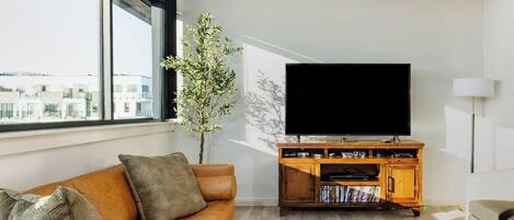 Luksusleilighet, balkong, byutsikt | Oppholdsområde | En 65-tommers smart-TV med digitale kanaler samt TV-spill og DVD-spiller