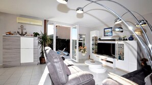 A modern living room with a sofa, TV, and a dining area. - Lovely home in Lézignan-Corbières (Lézignan-Corbières)