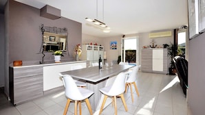 A modern kitchen with a central island, white chairs, and a dining table. - Lovely home in Lézignan-Corbières (Lézignan-Corbières)