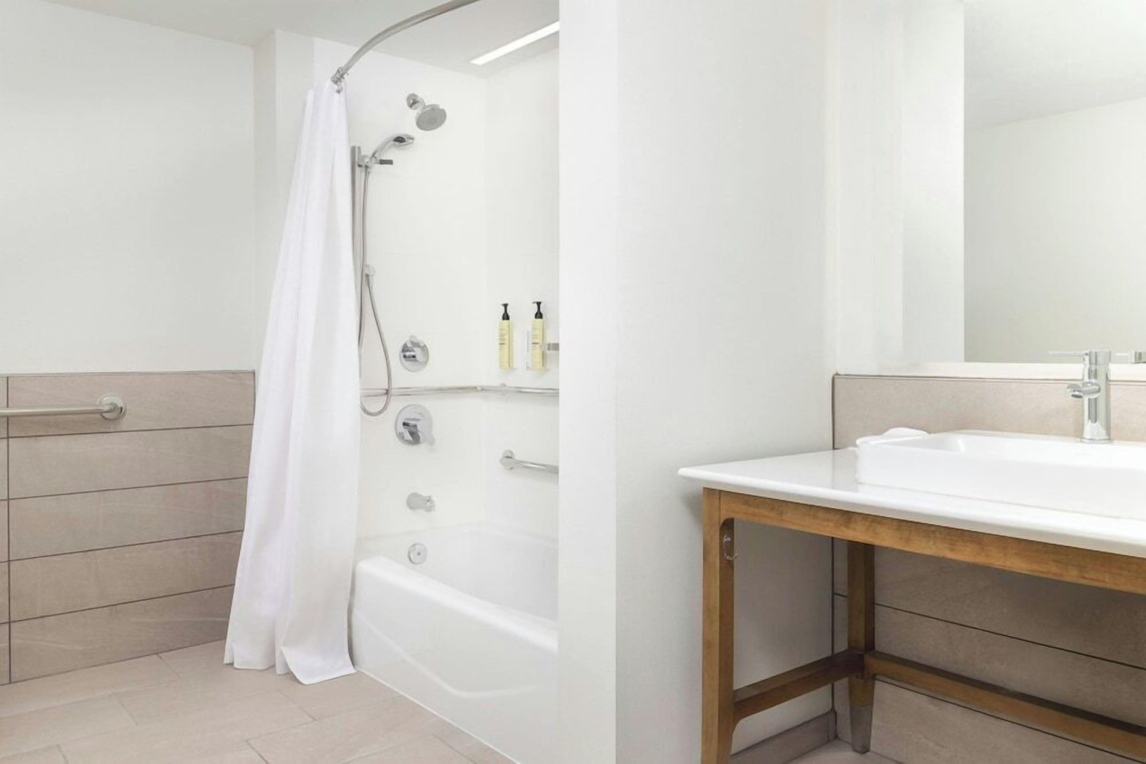 Un baño moderno con ducha, lavabo y espejo.