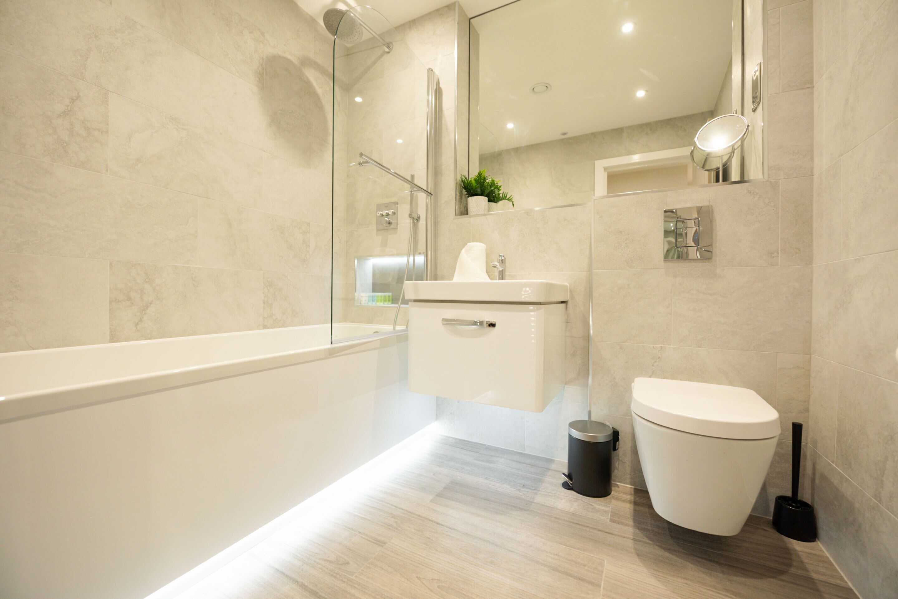 Une salle de bain moderne avec une douche à parois de verre, un lavabo blanc et des toilettes.
