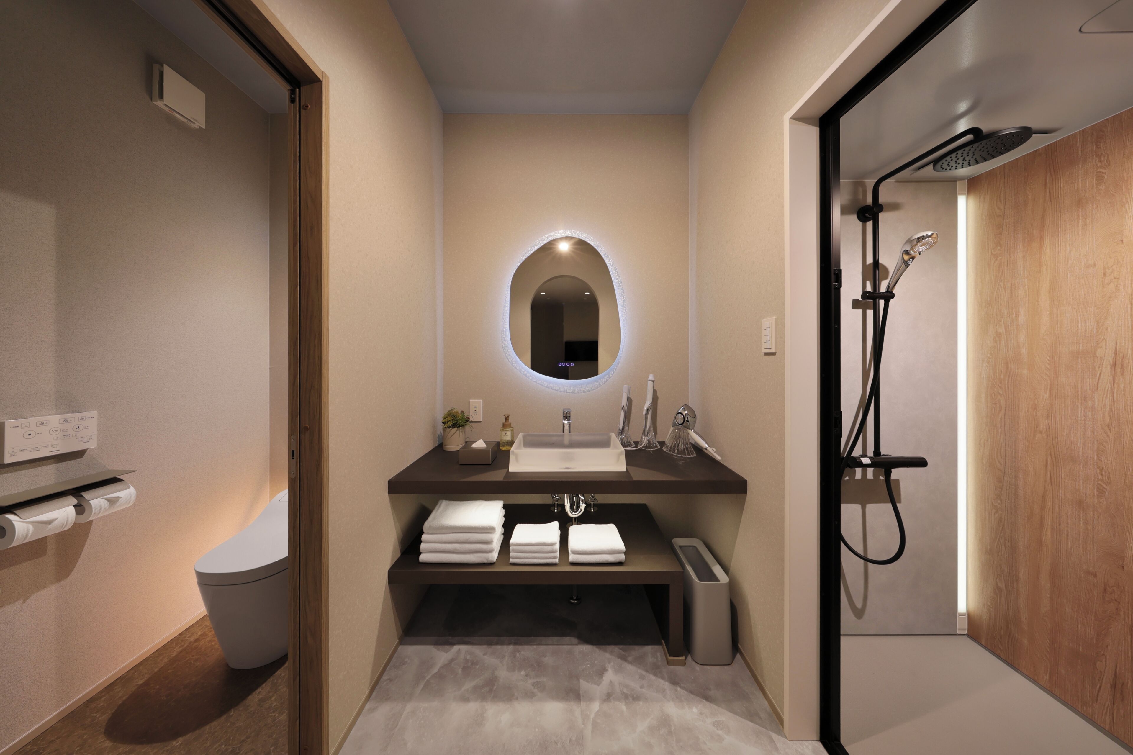 A modern bathroom with a vanity, sink, mirror, and shower.