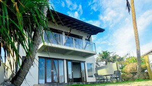 A modern two-story house with large windows, a balcony, and a stone pathway leading to the entrance. - Surfside Serenity Ahangama (Ahangama)