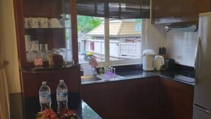 A kitchen with a sink, countertop, and a view of the outside. - Villa21Chaam (Cha-am)
