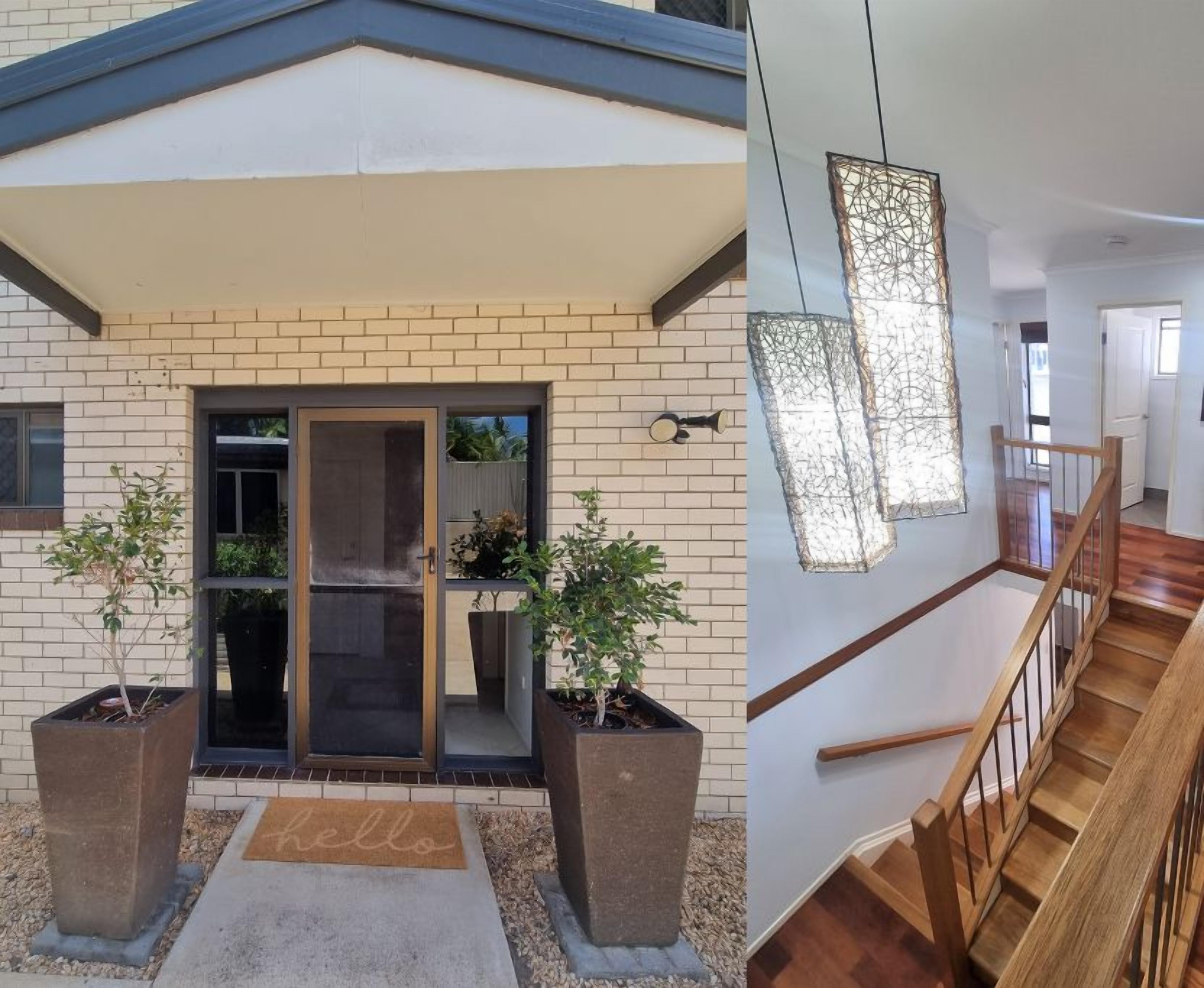 A modern building exterior with a brick facade, large sliding glass doors, and potted plants.