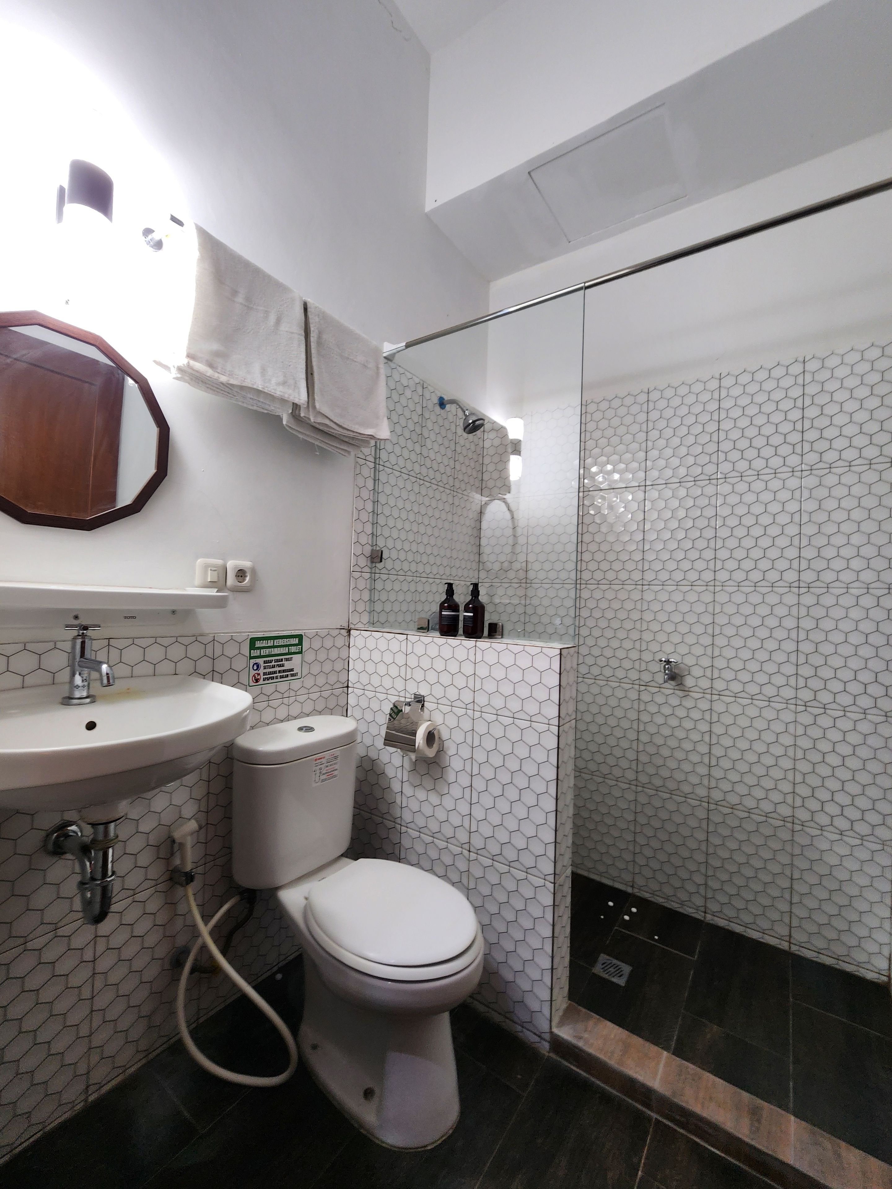 Une salle de bain comprenant des toilettes, un lavabo et un espace douche.