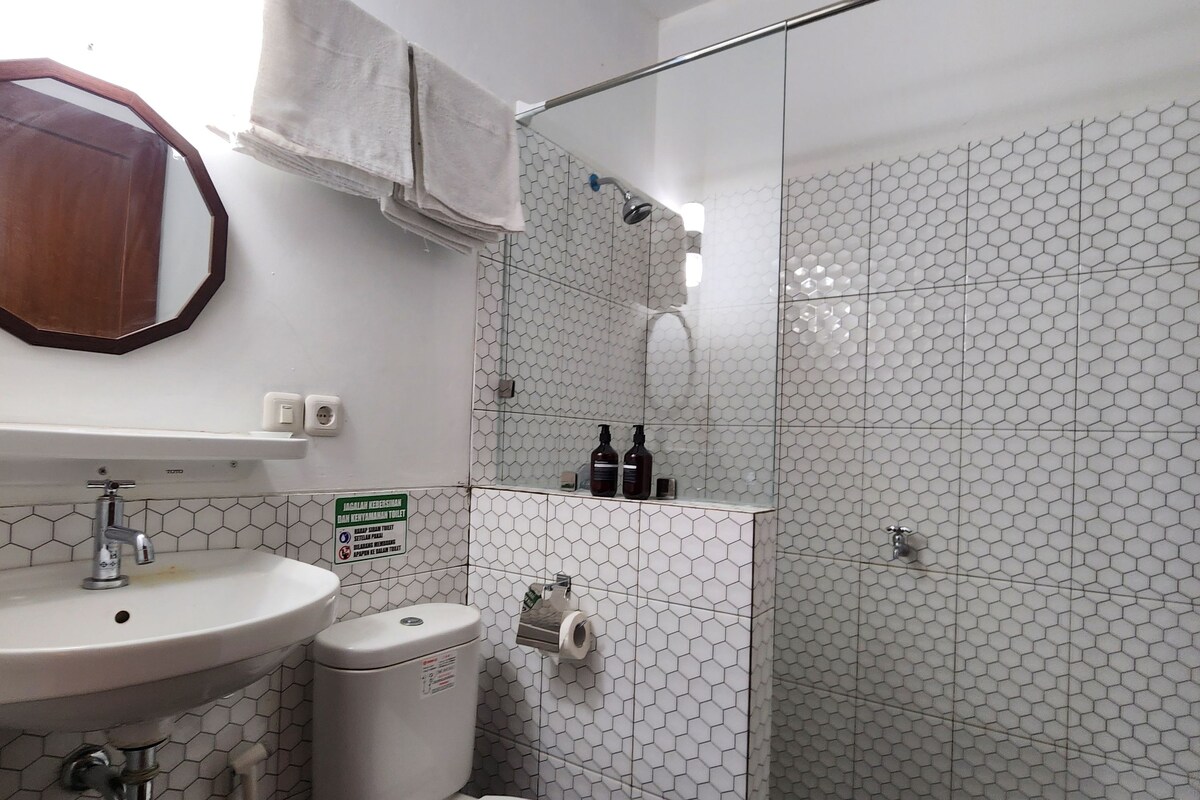 A bathroom with a toilet, sink, and shower area.