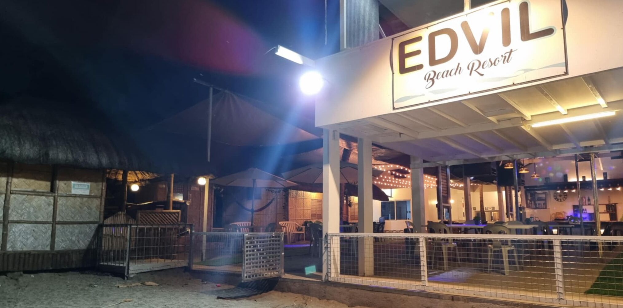 A beach resort named EDVIL with outdoor seating and a covered area.