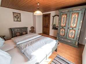 Un dormitorio con cama, armario de madera y lámpara en el techo.