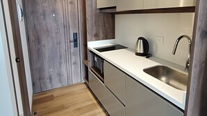 Ett modernt kök med trägolv, rostfria vitvaror och en stilren design.