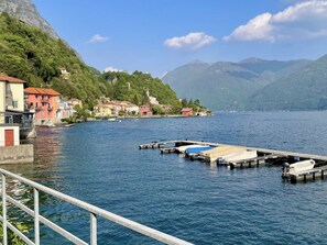A lakeside town with buildings, a dock, and mountains in the background. - Miralago by Interhome (Valsolda)