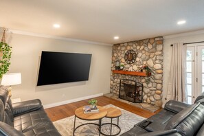 Smart-tv, een open haard, een tafeltennistafel en boeken