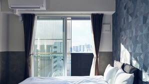 A hotel room with a bed, a window with curtains, and a city view. - MONTANA WING YEBISU (Osaka)