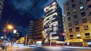 A multi-story building with illuminated windows and a visible storefront with signage. - MONTANA WING YEBISU (Osaka)