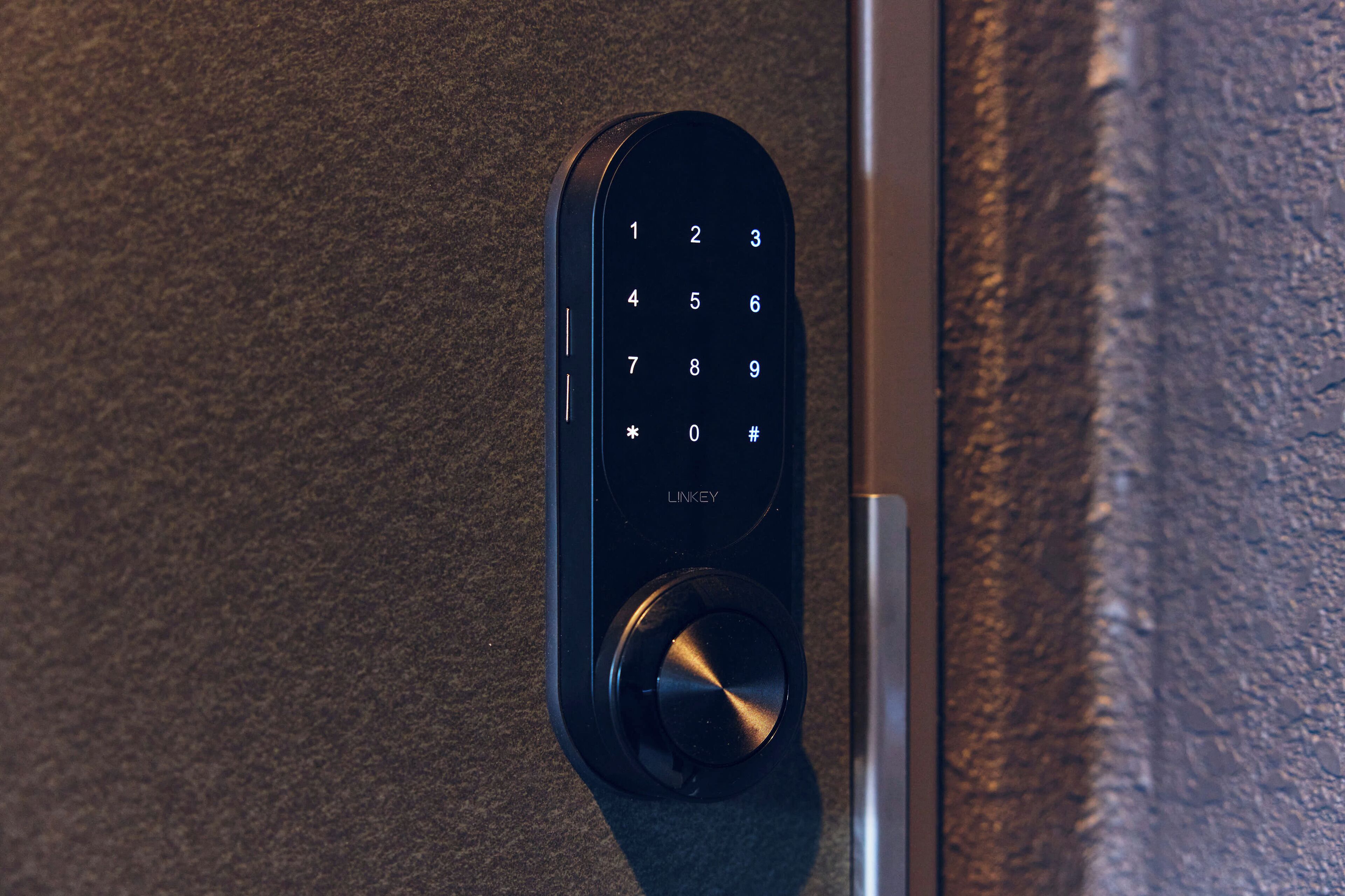 A close-up of a modern door lock with a numeric keypad and a keyhole, indicating a secure entry point.