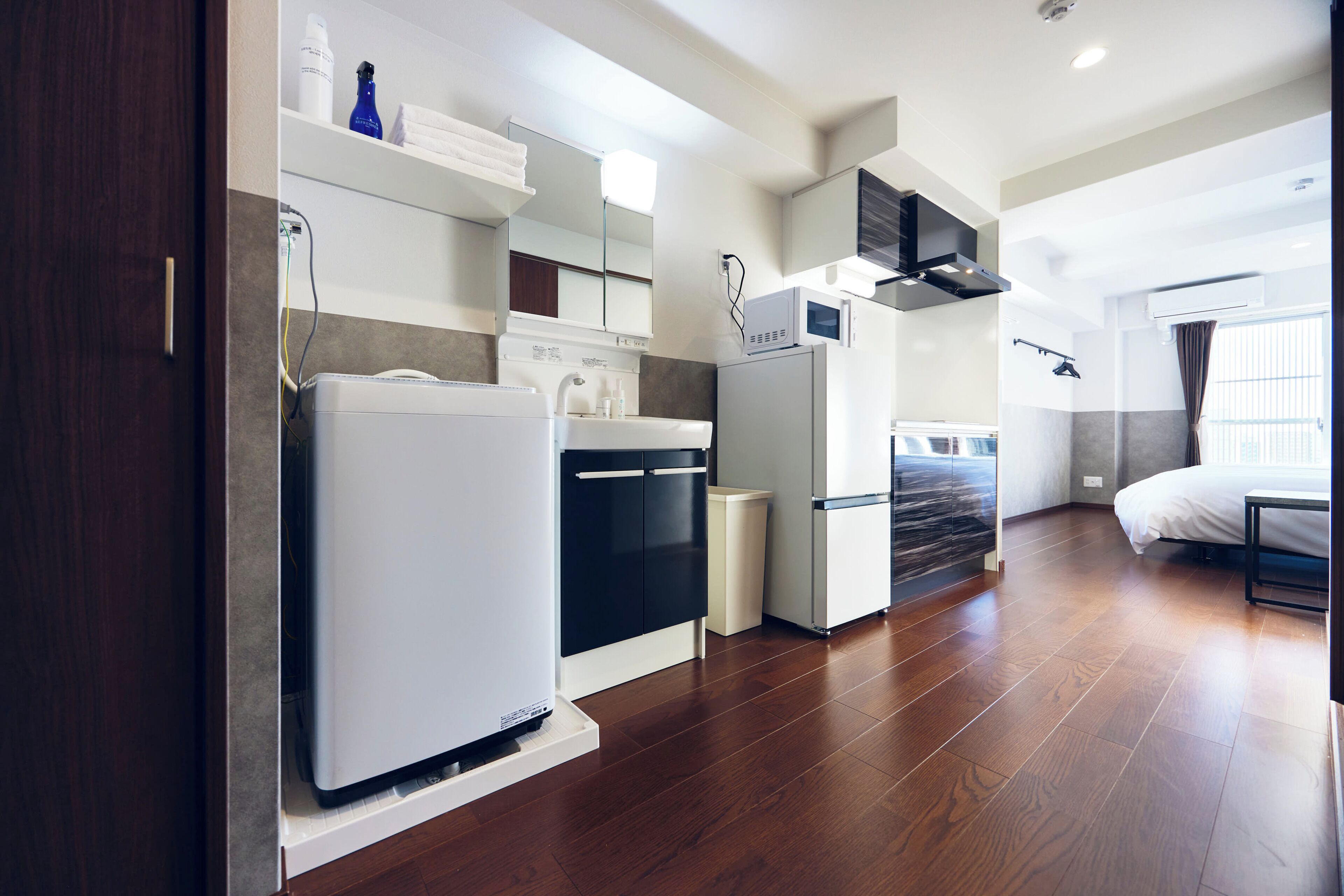 Una cocina compacta con electrodomésticos modernos, horno empotrado y microondas.