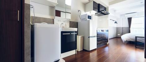 Una cocina compacta con electrodomésticos modernos, horno empotrado y microondas.