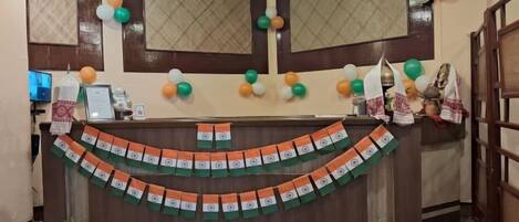 A reception area with a counter, decorative balloons, and a patterned wall.