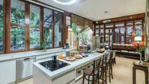 Una cucina moderna con isola centrale, elettrodomestici integrati e ampie finestre con vista sul verde.