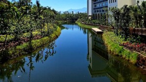 Una vista tranquila a orillas del río, con un edificio moderno que incluye una torre y un puente.