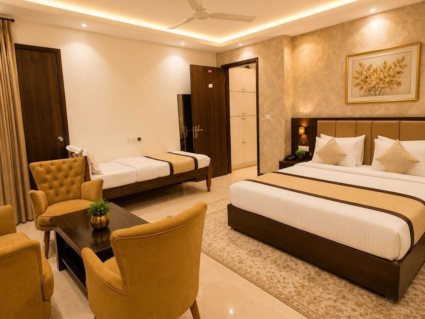 Une chambre d’hôtel avec un grand lit, un lit plus petit, un bureau avec des chaises et un ventilateur de plafond.