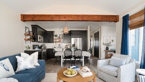 Ein modernes Wohnzimmer mit einem blauen Sofa, einem gestreiften Sessel und einem Holztisch.