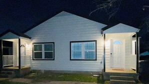 A two-story house with a front porch and a garage. - Cozy 2-bedroom townhome in charming Dallas with WiFi, AC (Dallas)