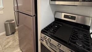 A kitchen with stainless steel appliances, including a refrigerator, microwave, and stove. - Cozy 2-bedroom townhome in charming Dallas with WiFi, AC (Dallas)