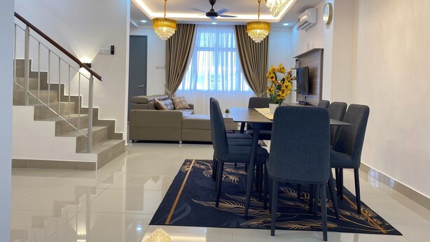 A modern living room with a dining area, a staircase, and a sofa. - D'Royale Desaru Homestay (Bandar Penawar)