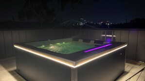 Tinaco exterior con calefacción e iluminación LED, rodeado por una terraza de madera.