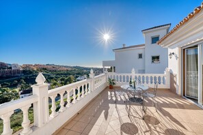A balcony with a white railing, a table with chairs, and a potted plant. - 3077 Luxury Villa with Pool and Views in Elviria, Marbella (Marbella)