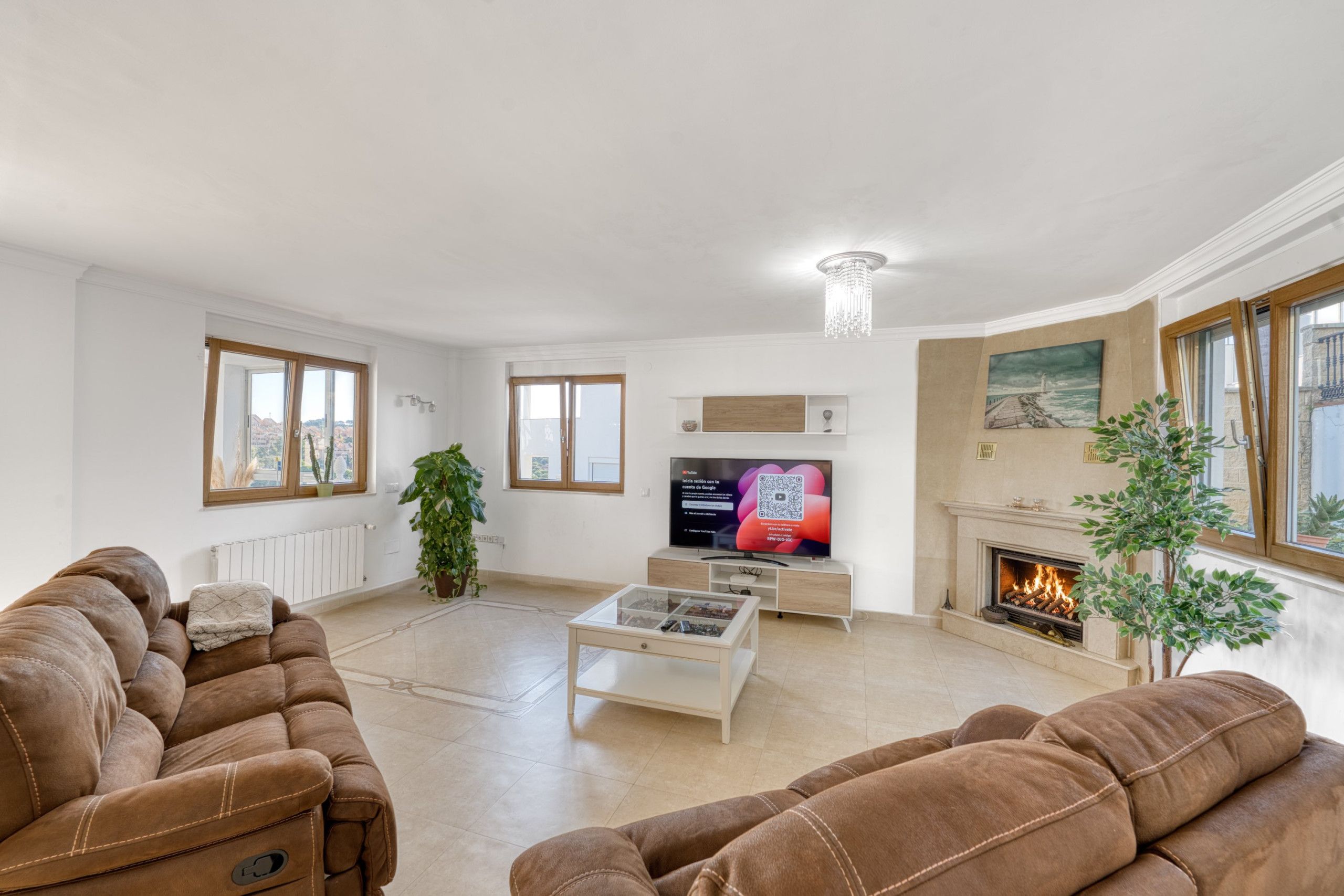 A living room with a fireplace, a television, and a sofa.