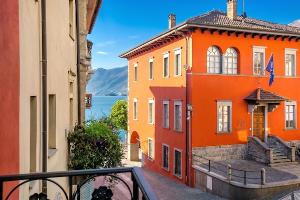 A building with a red facade, a flag, and a view of a lake.