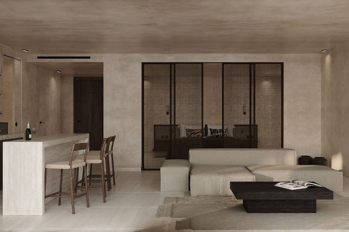 A modern living room with a minimalist design, featuring a sofa, a coffee table, and a dining area with chairs and a small kitchen counter.