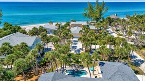 A coastal property with a swimming pool, multiple houses, and a beach. - Steps to Beach | Pool + Hot Tub | 2025 Remodeled! (Englewood)