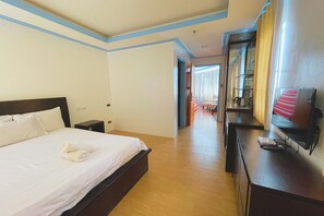 A hotel room with a large bed, a desk, a TV, and a mirror. - Here Innstead Boracay powered by Cocotel (Boracay Island)